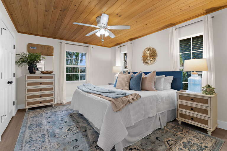 Wake up in the second bedroom to natural light through two windows and a calming blue headboard that makes the whole room feel like a breath of Gulf Coast air.