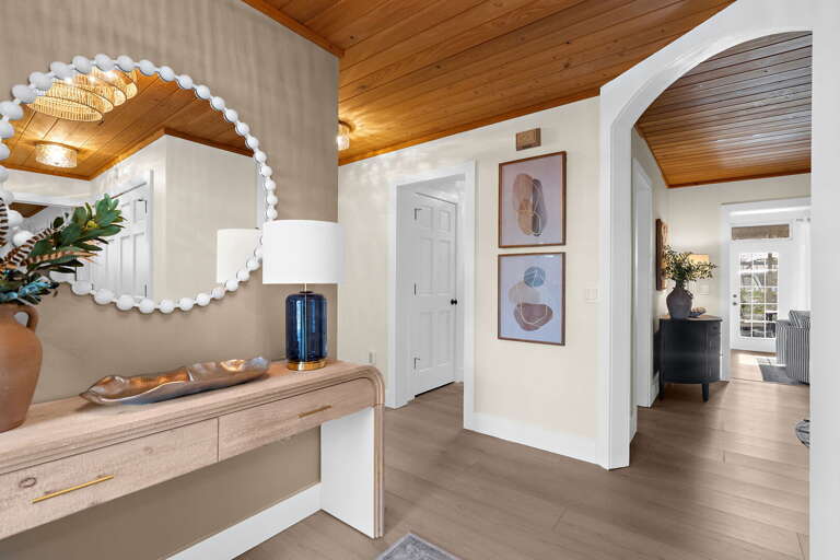 Walk through the arched French doors and feel the whole vibe shift — wood-plank ceiling, cool air,