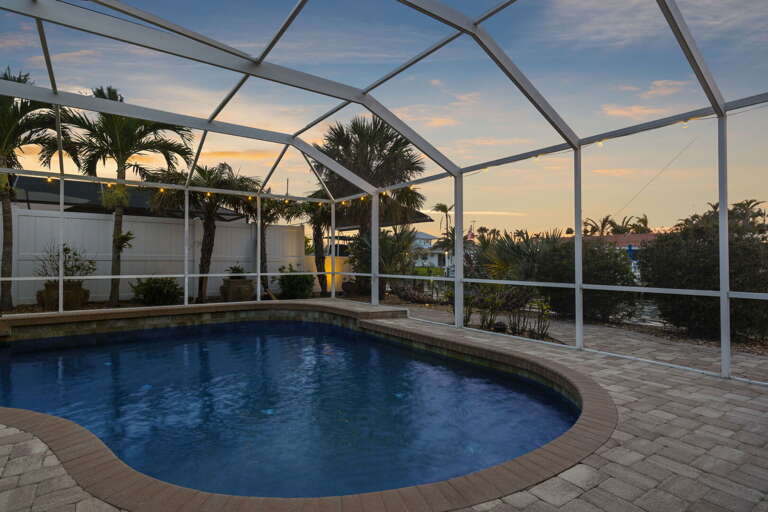 Watch the sky shift from blue to pink to deep orange while the pool glows beneath the screen — dusk at this house is genuinely hard to walk away from.
