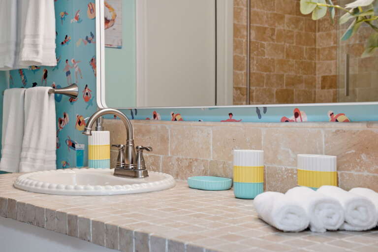 Every little detail counts! Fresh towels, cheerful accents, and a fun beach mural make getting ready part of the vacation.