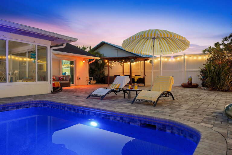 Evenings never looked so good! String lights twinkle over the patio while the pool glows just steps away.