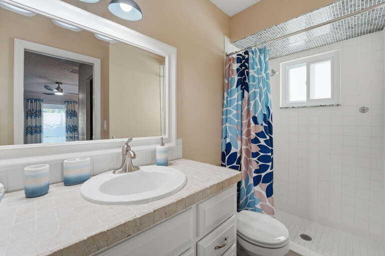 Freshen up in style! Our bright, beach-chic bathroom features a shower and cheerful coastal accents to start your day the right way.