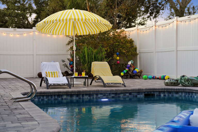 Golden hour just got better! String lights twinkle to life as the sun sets over your private, colorful poolside escape.