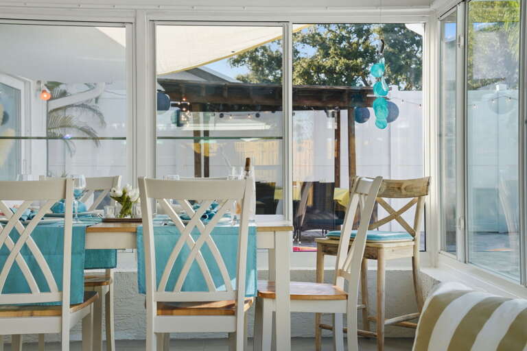 Seat everyone at once with the pool and pergola framed just outside — Florida evenings hit differently from this table.