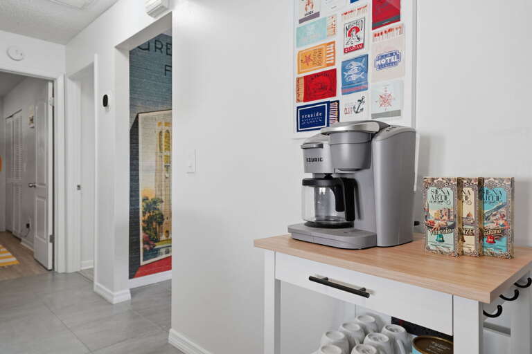 Start every morning with the drip machine going and the travel poster picking your next destination — coffee bar stocked, mugs out, the day is yours.