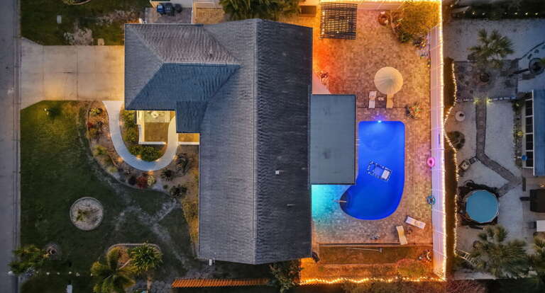 See it all from above! This stunning aerial view shows off your private pool, cozy layout, and twinkling lights — pure paradise from every angle.