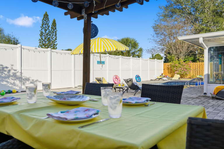 Sunny days call for pool-view dinners under the pergola — cheers to that