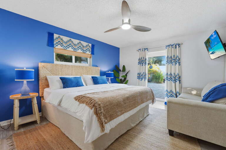 Wake up to island vibes! This vibrant king suite pairs breezy coastal decor with a cozy lounge nook — your own private retreat after a day at the beach.