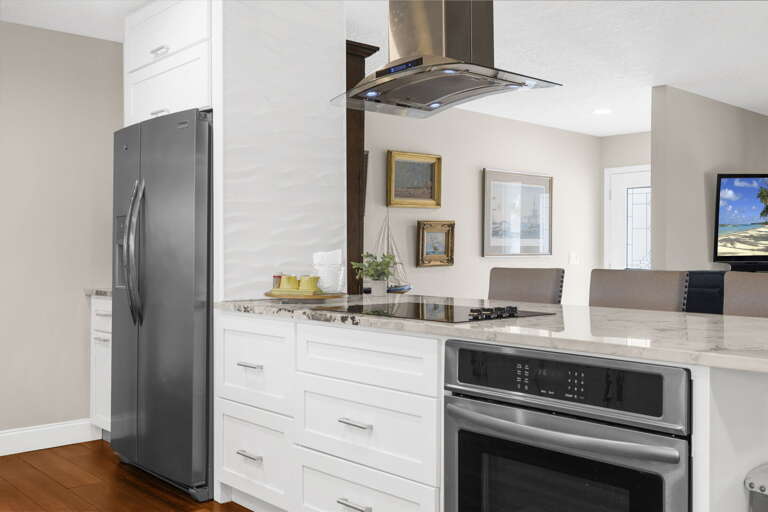 Cook a real dinner here — wall oven, stainless fridge, cooktop on the island, and enough counter space so two people can work the kitchen without getting in each other's way.