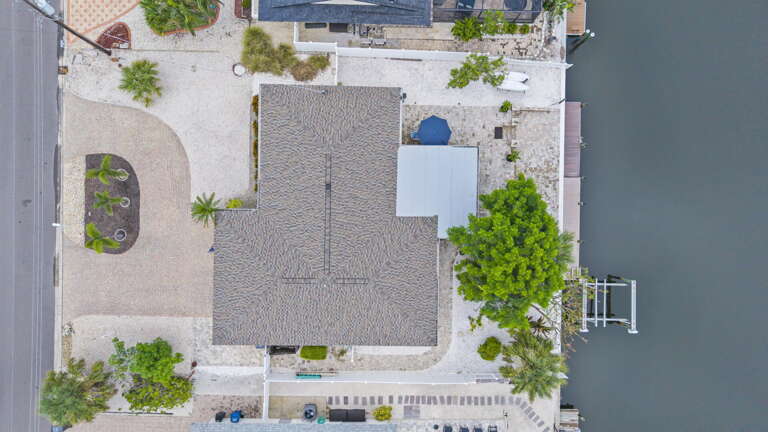 Your dock from directly above — boat ties up right there at the canal edge, yard and patio all around it.