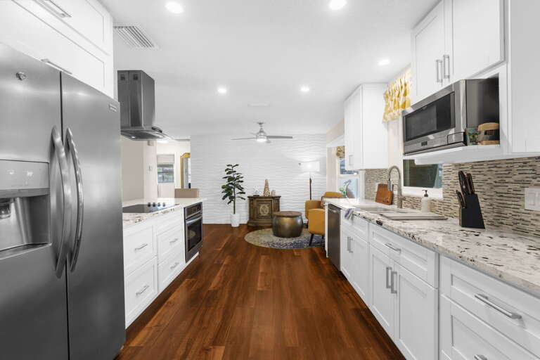 Everything you need for a full week of real cooking — wall oven, electric range, full-size fridge, and island seating.