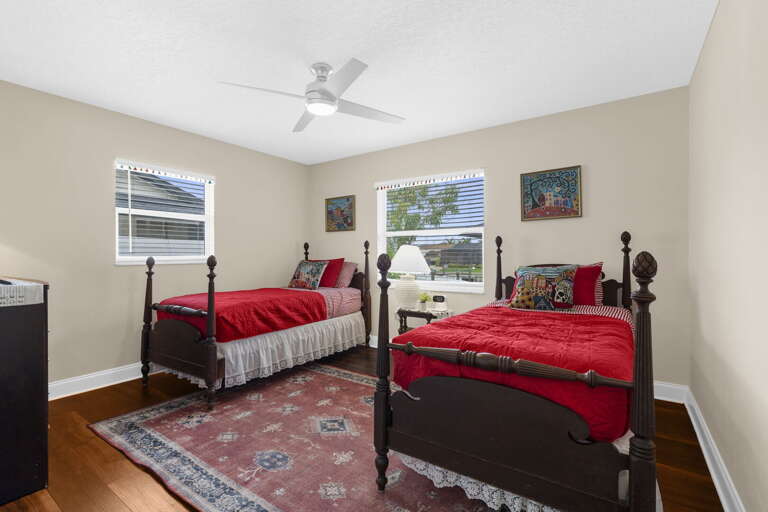 Give the kids their own room and let them fight over which side — this twin room has the fan, the hardwood, and enough space for your youngest two.