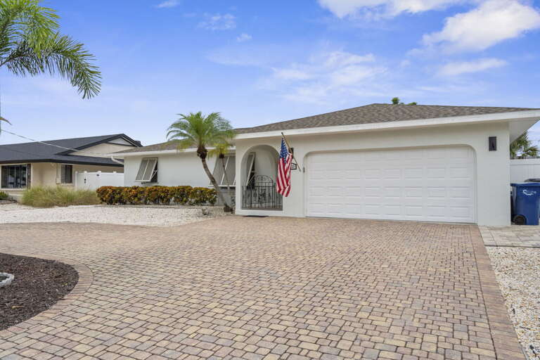 Pull into the brick paver driveway and let your vacation officially begin — white stucco, two-car garage, and easy street parking.