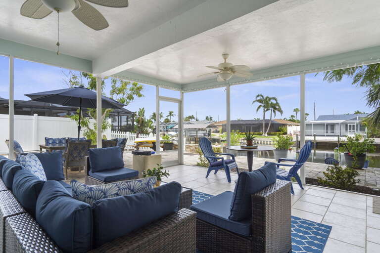 Settle into the sectional and let the canal breeze do the rest — your screened lanai fits the whole group and stays comfortable all evening.