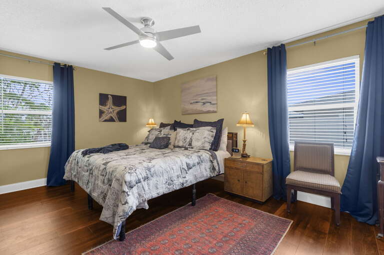 Sleep in on your first morning after a day on the water — King bed, ceiling fan overhead, and coastal art that keeps things calm.