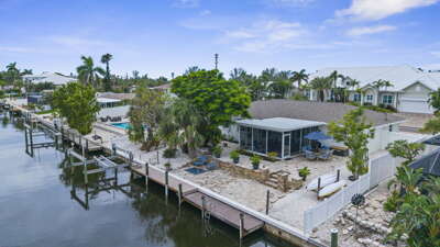 Your waterfront retreat from above — private dock, paver patio, screened lanai, and the canal right in your backyard waiting for you.
