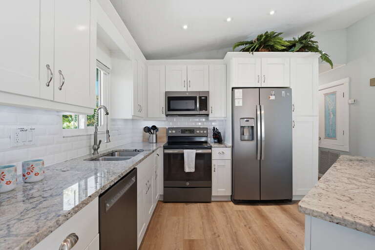 Everything you need for home-cooked meals is here — stainless range, microwave, refrigerator, dishwasher, and granite throughout.