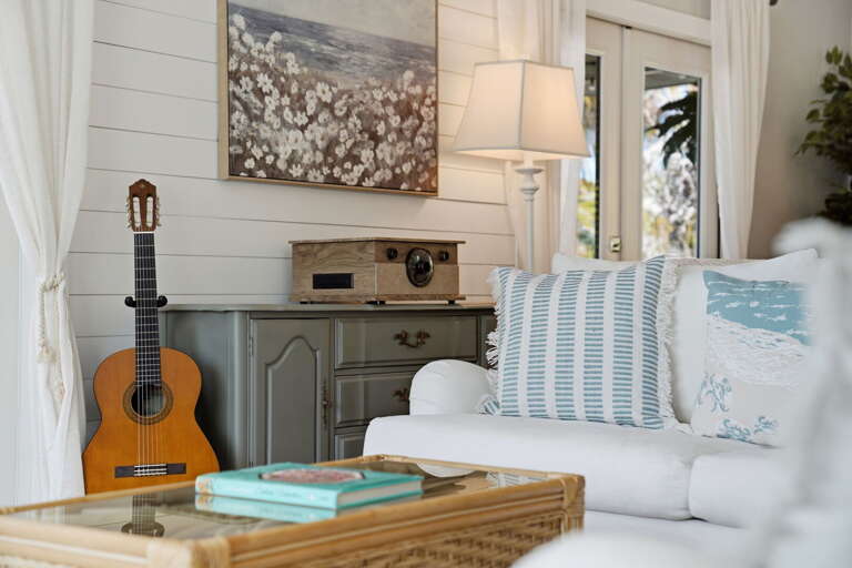 Grab a mug from the Keurig in this corner — the guitar is there if inspiration hits, and coastal pillows are just beside you.