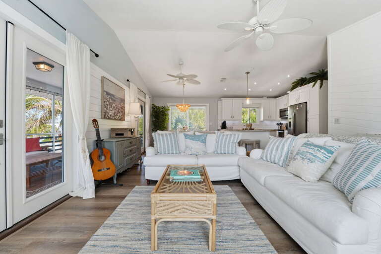 Your main gathering room opens straight to the screened porch through French doors — pull them open and inside becomes outside.