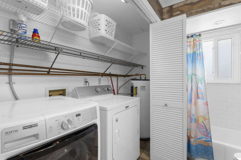 Run a load between beach days — full-size washer and dryer right here with wire shelving above for extra storage.
