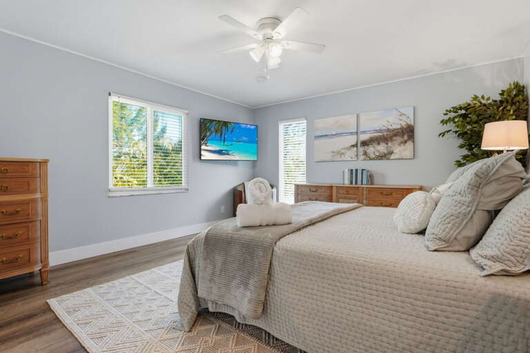 Wake up in the king master bedroom — ceiling fan overhead, mounted Smart TV, and your private ensuite through the door.