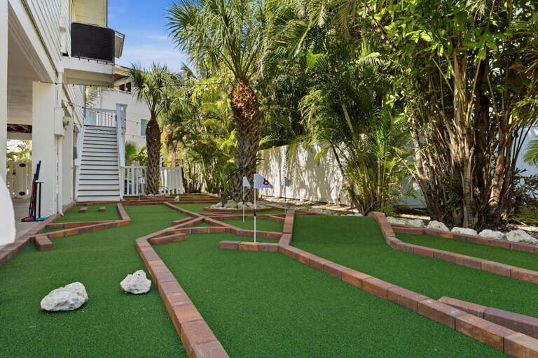 Take in the whole course from above — winding mini golf holes through tropical landscaping fill the backyard completely.
