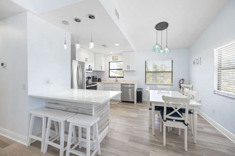 Cook for the whole group without bumping elbows — the island seats four, the stainless appliances are full-size, and the dining table is two steps away.