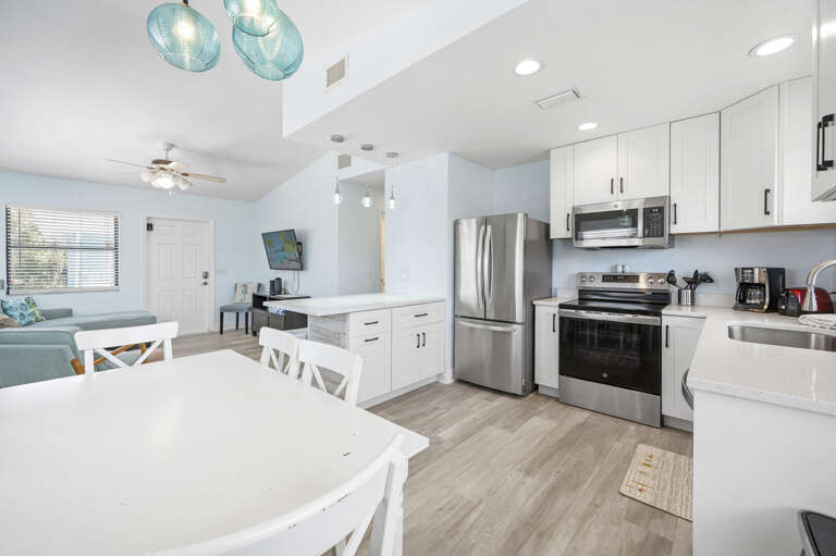 Sit down at the dining table and look across to the full kitchen — range, refrigerator, and counter space all yours.