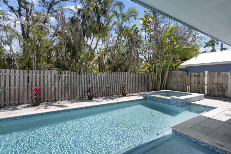 Soak in the hot tub framed by tropical palms and flowering plants — this is the spot after a long beach day.