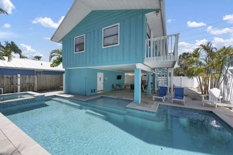 Step outside and take it all in — heated pool, hot tub, shaded patio, and a balcony above for morning coffee.