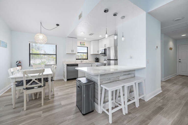 Cook at the island and carry it two steps to the table — kitchen and dining are this close. Post-beach meals are easy here.