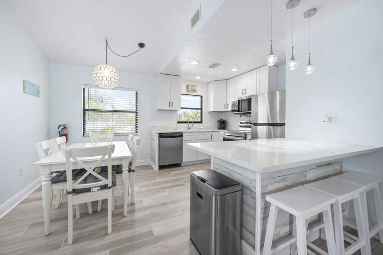 Find everything you need in this kitchen — quartz counters, stainless appliances, a bar island with stools. Cook a real meal without fighting for counter space.