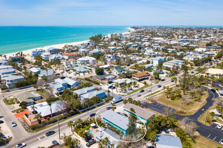 Find your property in this drone pass — beach and turquoise water unmistakably close, just 200 steps from the front door. This is what close-to-the-beach actually looks like.