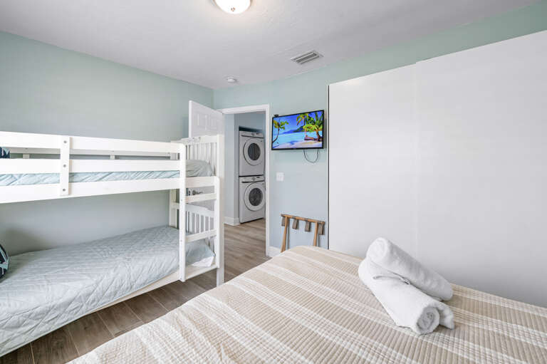 Set the kids up with their own screen — wall-mounted TV in the bunk room, washer right outside the door. You keep the living room remote.