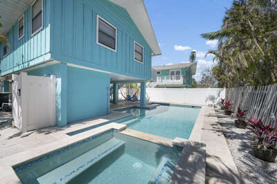 Shared pool runs the full length of the yard. Hammock's already up. Deck steps lead to the upper floor. All of this is yours the moment you check in.