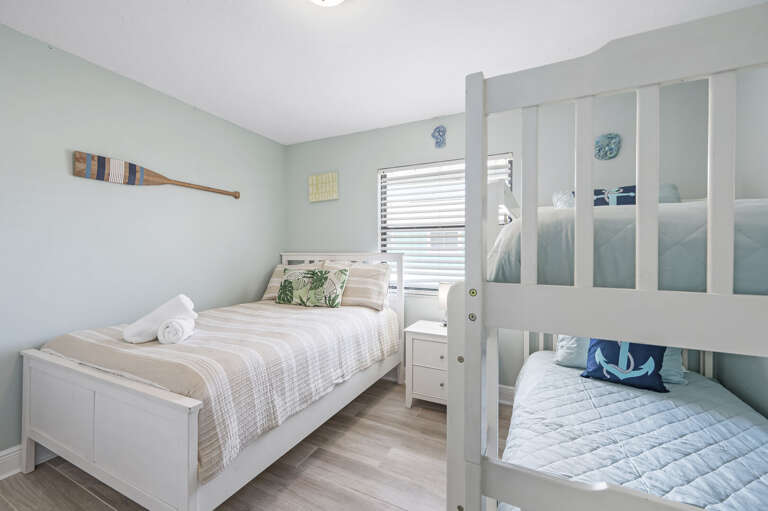 Watch the kids fight over the top bunk before you even finish carrying in the luggage — coastal decor and bunk beds stacked and ready.