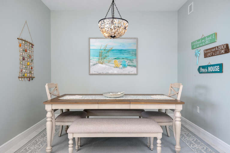 Seat the whole crew around the dining table — a chandelier overhead and beach art on the walls.!