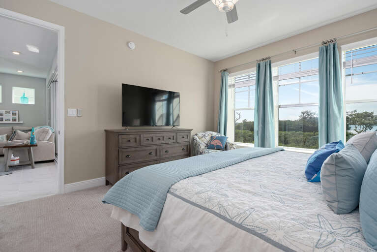 Sleep deeply in your master bedroom — king bed, ceiling fan, and morning light off the Anna Maria Sound.