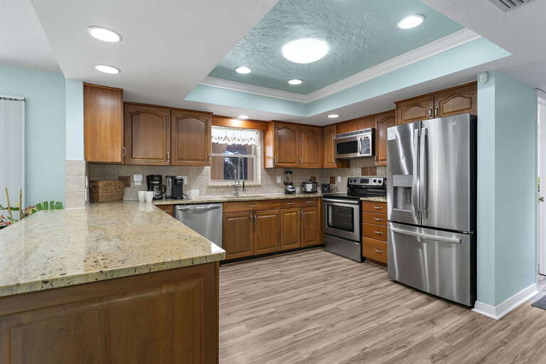 Cook a real meal here — full run of cabinets, island counter, dishwasher, everything your group needs.