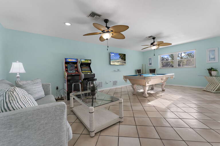 Find your rainy-day plan here — pool table, two arcade cabinets, big sofa. Zero consolation-prize energy.