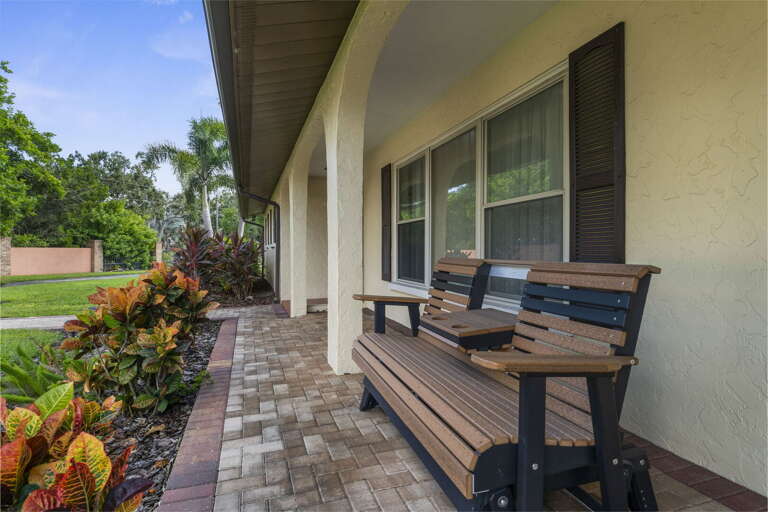 Pull into the front porch with the bench glider waiting — the kind of arrival that already feels like the trip started.