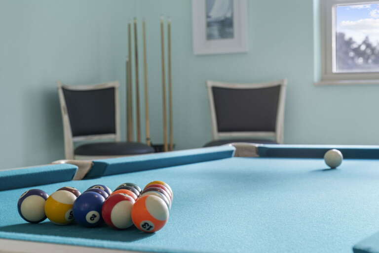 Rack up on the turquoise pool table, call solids or stripes, let the tournament begin.