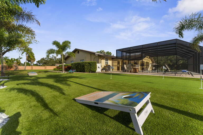 Set up cornhole on the lawn between the pool screen and the lake — the kids tournament that lasts the whole afternoon.