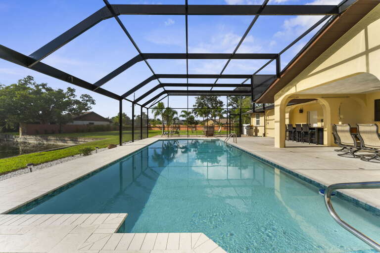 Stake your lounger, slide into the shade, keep an eye on the kids without yelling — the screened pool keeps the bugs out and the day in.
