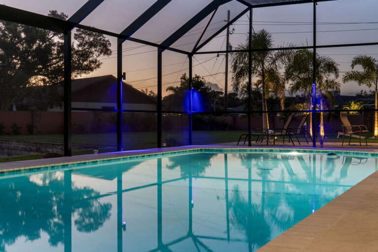 Stand on the sunset side of the pool, palm shadows on the screen — the photo your group keeps taking.