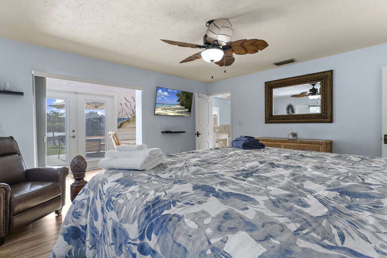 Wake up in the primary bedroom, take in the framed mirror, leather seating, and the lake outside.