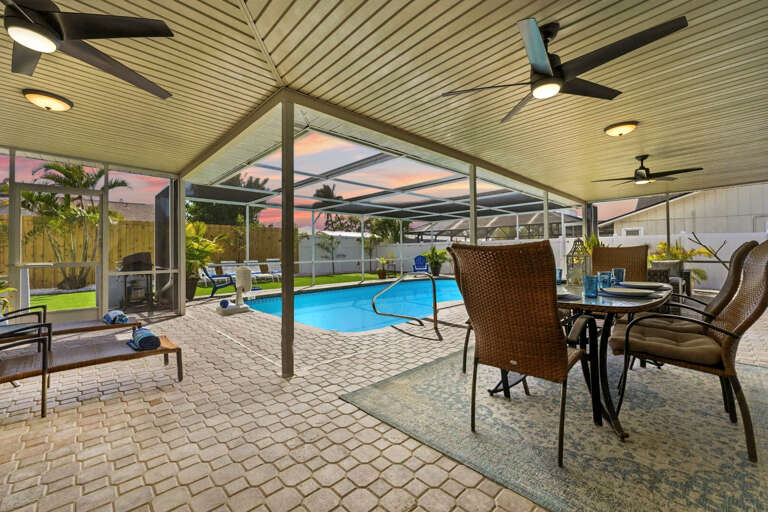Sit under the covered lanai with a cold drink and let the day slow down — the pool glimmers just steps from your chair.