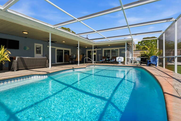 Splash into your own screened heated pool — palms swaying, no one else in sight but your crew.
