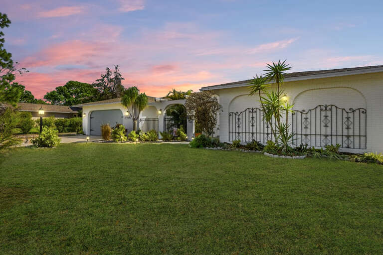 Step through the arched entry at dusk — your Florida retreat glows with warmth before you even reach the front door.