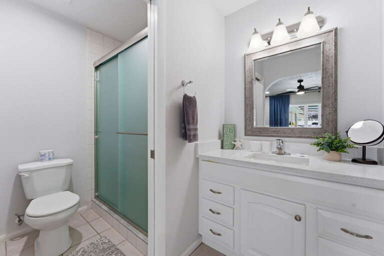 Step into the glass-door shower and rinse off the beach — the bathroom is clean, well-lit, and ready for you every morning.